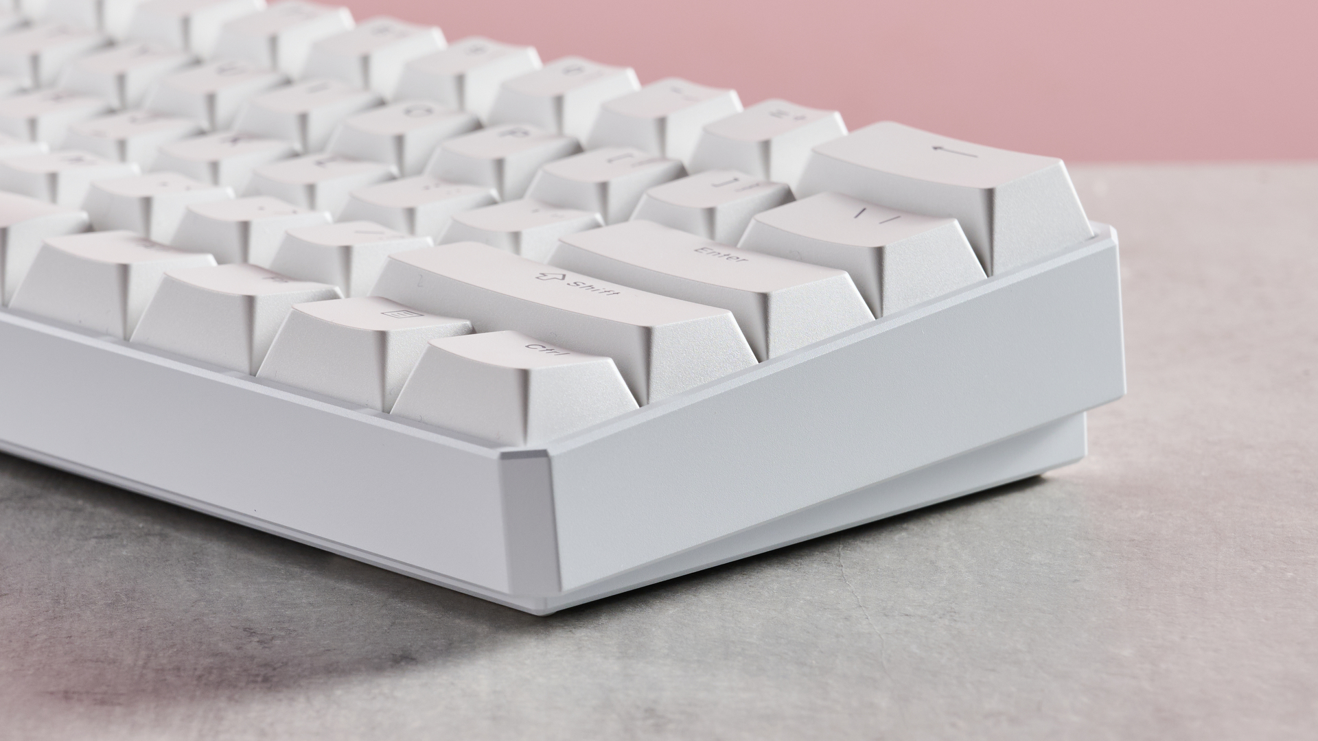 Close-up of side of MonsGeek FUN60 Ultra, on desk with pink background