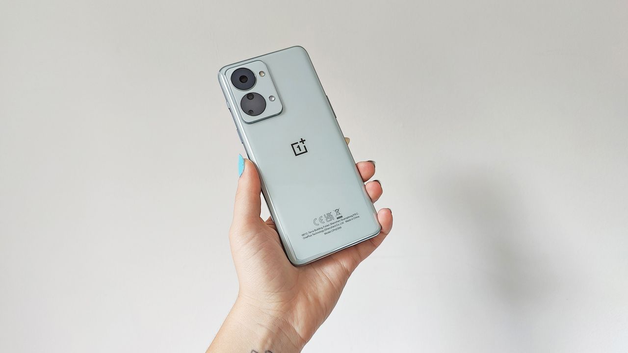 OnePlus Nord 2T review: woman holding phone against a wall