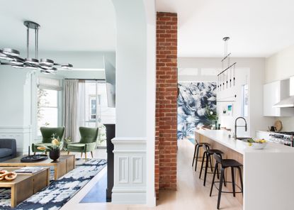 narrow kitchen in semi open plan space, long narrow kitchen island with sink and breakfast bar, artwork at the end