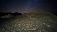 lines and circles carved into a rock, seen under a starry night sky