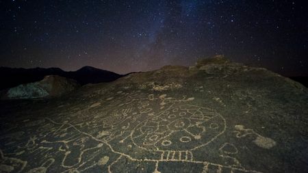 lines and circles carved into a rock, seen under a starry night sky