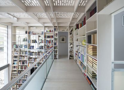 A vast library occupies a double height space at Tonkin Liu’s ‘Old Shed New House’ project in Yorkshire