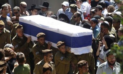Israeli soldiers carry a flag-draped coffin after violence erupted Thursday night in Israel and Gaza