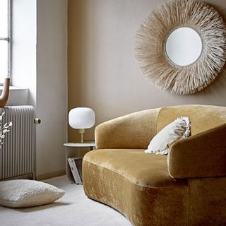 fringed mirror on wall and sofaset with cushions
