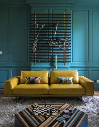 Blue panelled living room with yellow sofa