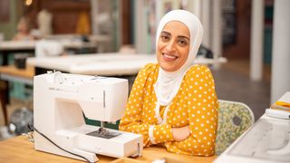 Asmaa in a white headscarf and yellow polka dot dress for The Great British Sewing Bee 2023