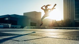 Young female athletes practising mid air martial arts kick