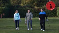 Male and female golfers walking off the tee