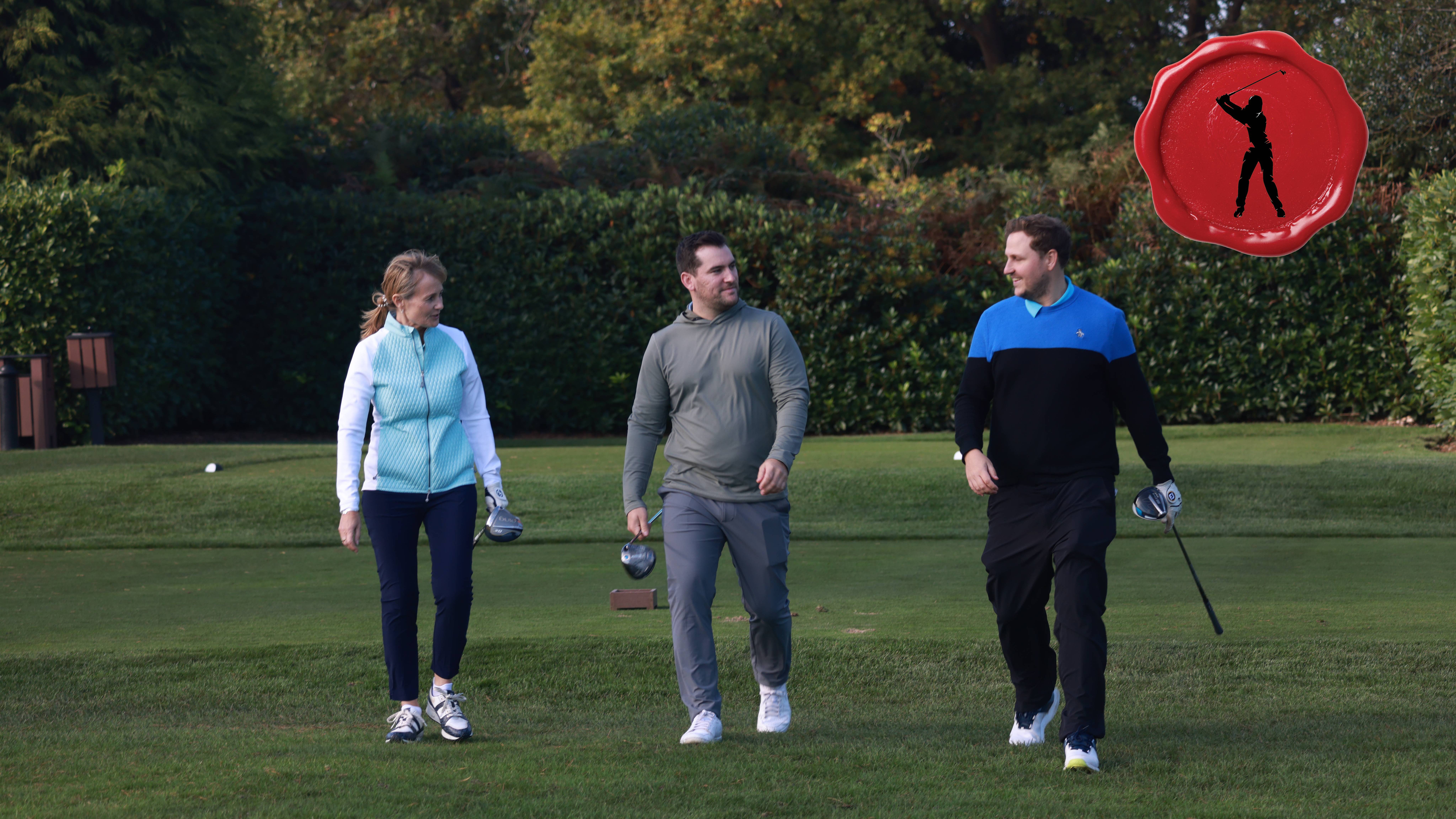 Male and female golfers walking off the tee