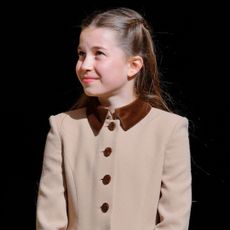 Princess Charlotte wearing a brown coat and smiling