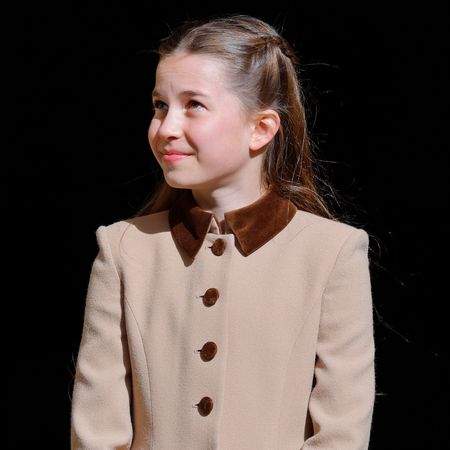 Princess Charlotte wearing a brown coat and smiling