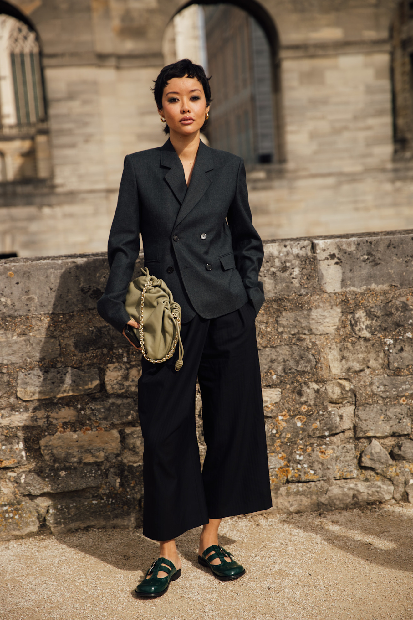 woman in black wide-leg linen trousers and a gray blazer