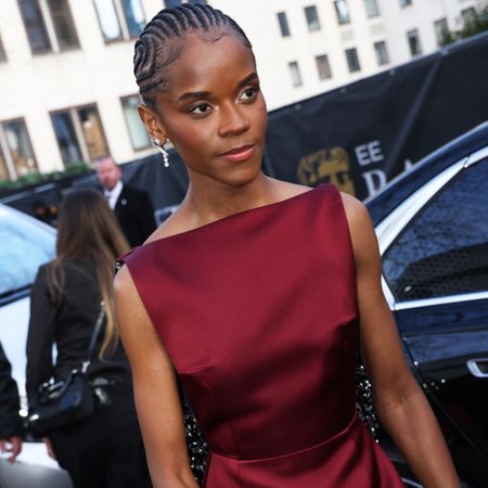 Letitia Wright wears a dark red dress and burgundy nails at the 2025 BAFTAS