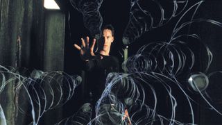 Keanu Reeves holds his hand up to stop bullets in the Matrix
