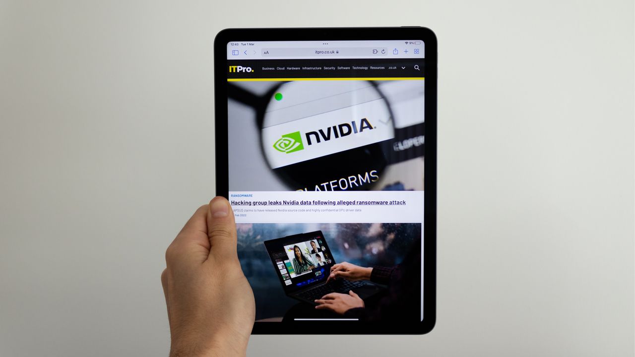 A photograph of the Apple iPad Air being held up in front of a wall