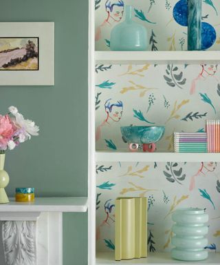 Illustrative wallpaper in bookshelf with duck egg blue wall and decor