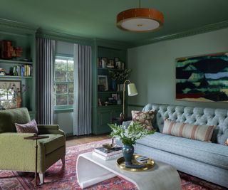 green walls library with gray sofa and green chair