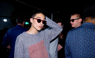 Male models wearing the Oliver Spencer S/S 2015 collection. The main model is wearing a gray jersey with a pink motive on it with sunglasses