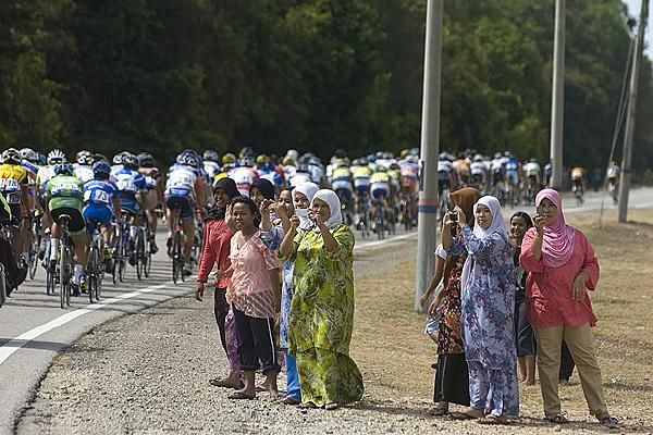 A photo opportunity arises for some locals as the peloton speed by on their way to Mersing.