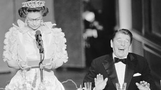 President Reagan laughs following a joke by Queen Elizabeth II, who commented on the lousy California weather she has experienced since her arrival to the States. The British Queen is delivering a brief address during a state dinner held at the De Young Museum in San Francisco.