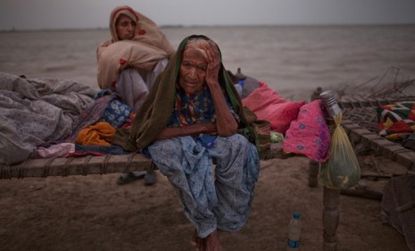 Pakistani women, whose families were displaced by floods, sit on a makeshift bed, as they take shelter on higher ground in Pakistan.