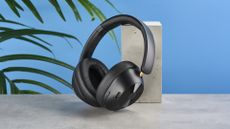 a pair of black bluetooth headphones made by OneOdio Focus A5 is photographed against a blue background