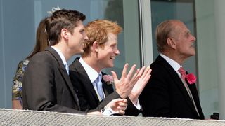 Jake Warren, Prince Harry and Prince Philip, Duke of Edinburgh on the balcony of the Royal Box as they attend Derby Day at the Investec Derby Festival at Epsom racecourse on June 4, 2011 in Epsom, England.