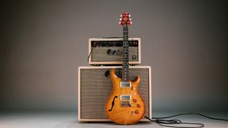 DGT Semi Hollow guitar against an amp