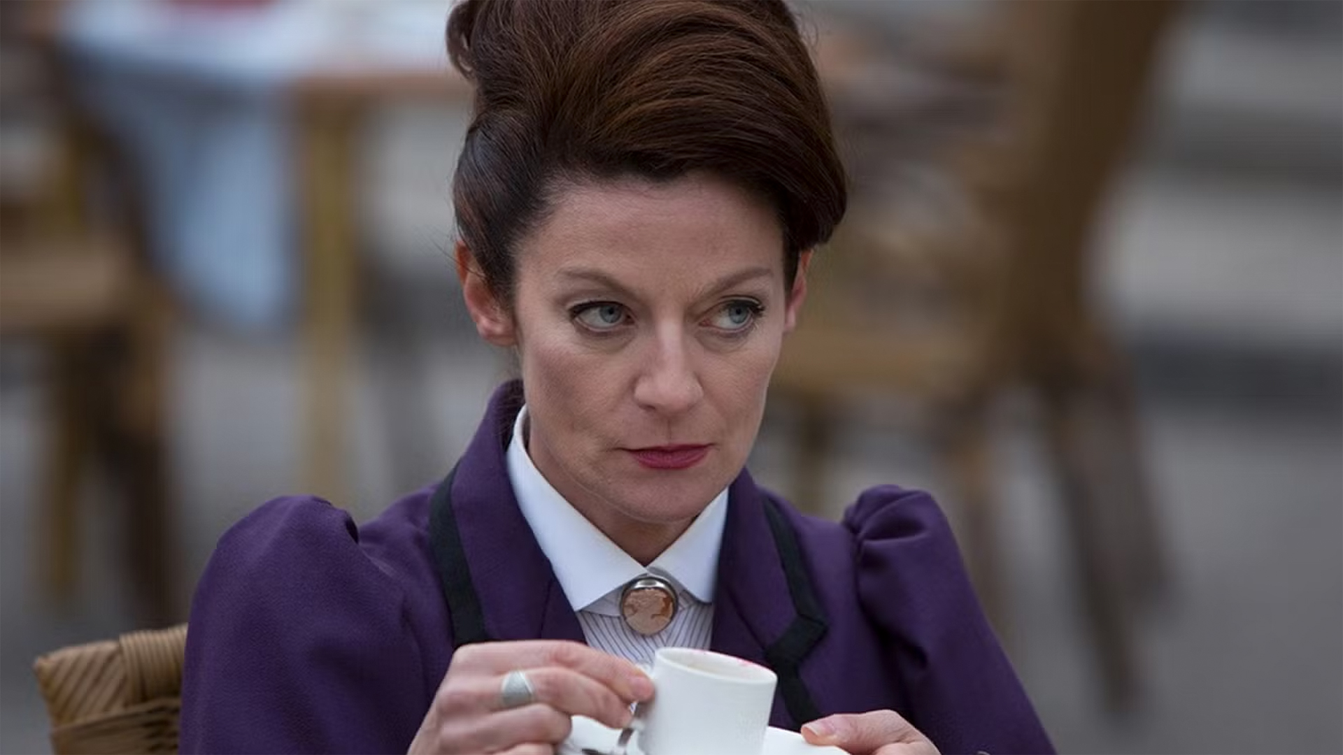 Missy (Michelle Gomez) drinks from a cup of coffee