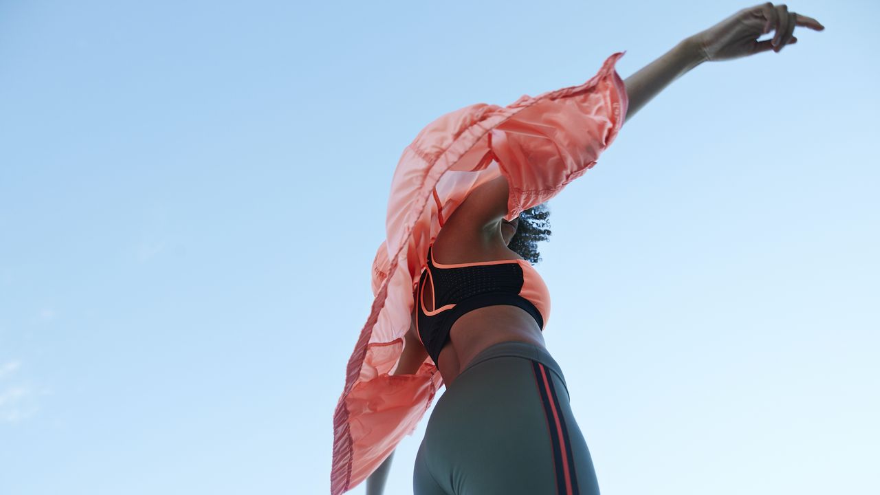 sports bra woman in sports bra and activewear against blue sky