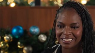 Samantha Marie Ware smiles in front of Christmas decorations