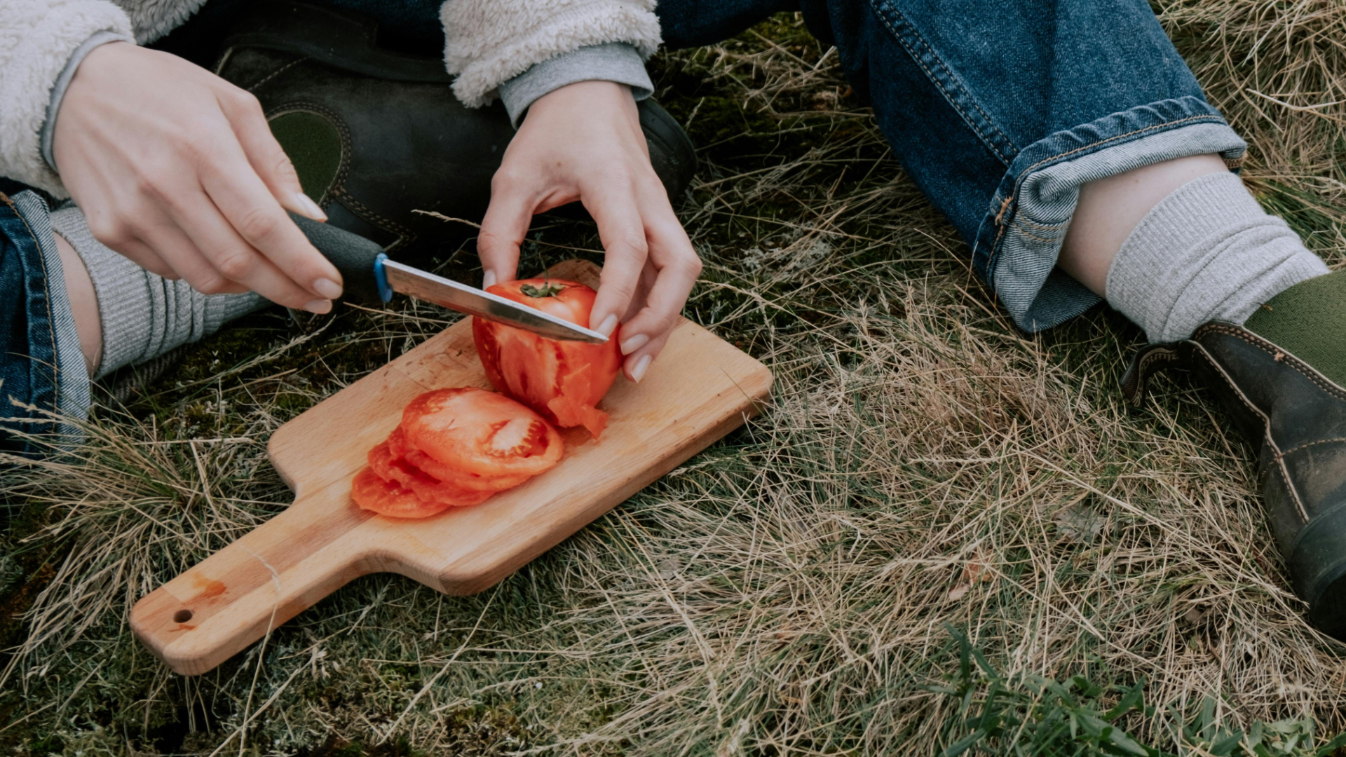 Camping knife cutting tomato