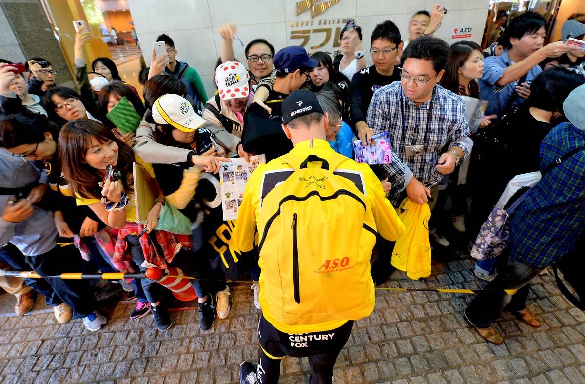 Chris Froome signs some autographs before the race
