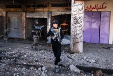 TOPSHOT - Members of the Iraqi special forces Counter Terrorism Service (CTS) walk next to destroyed shops in eastern Mosul on January 18, 2017. Iraqi forces have fully retaken east Mosul fro