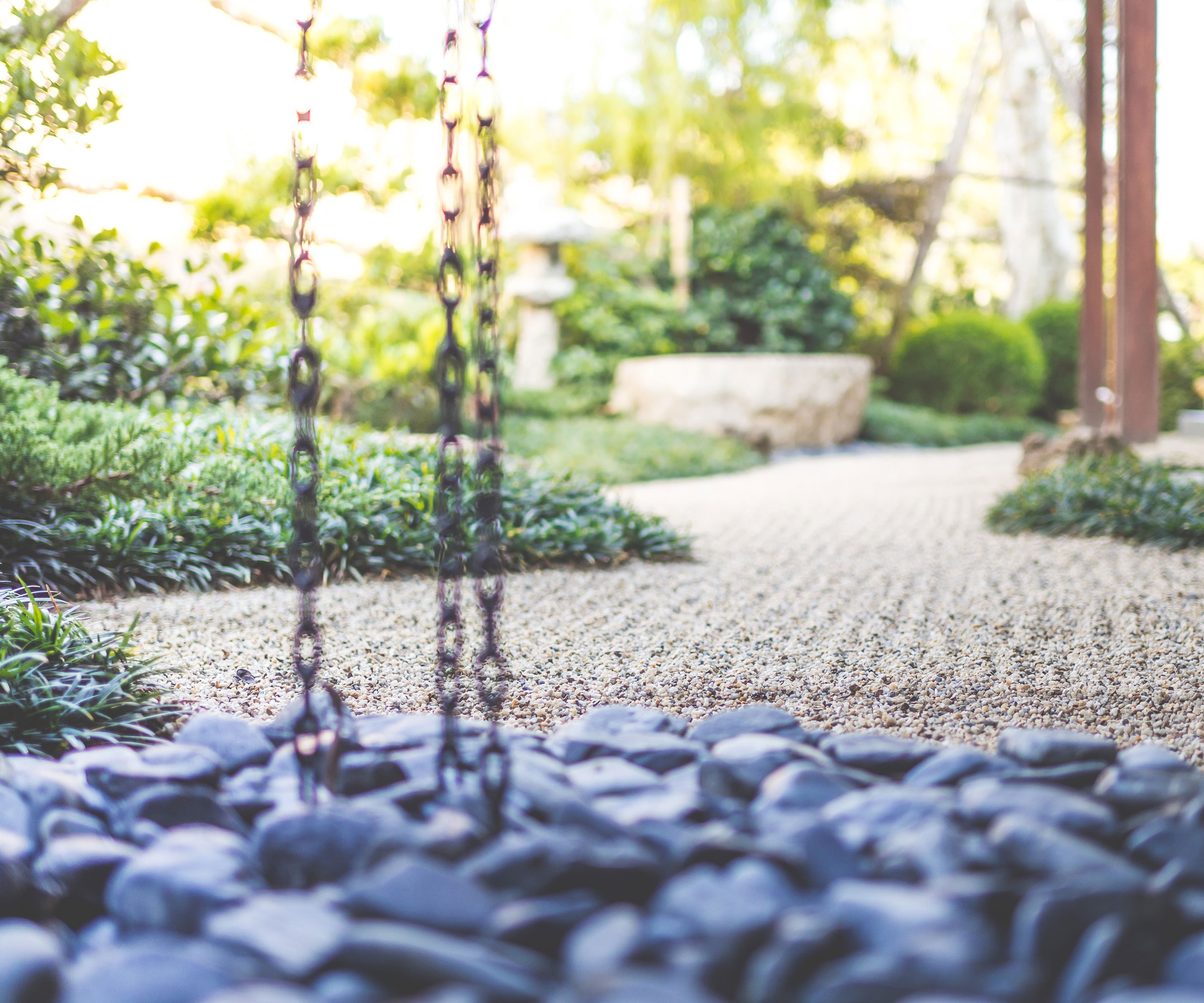 Japanese Zen garden design with raked gravel and pebbles with rain chain