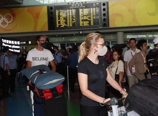 USA riders arrive in Beijing wearing face masks
