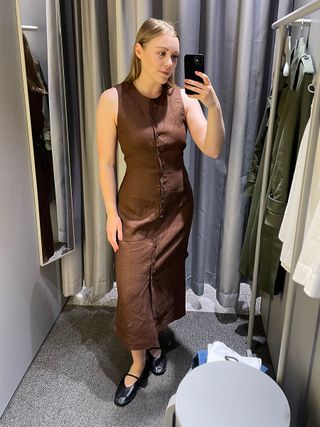 Woman in dressing room wears brown linen vest dress