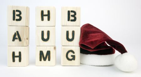 the words "bah hum bug" on wood blocks with a santa hat nearby
