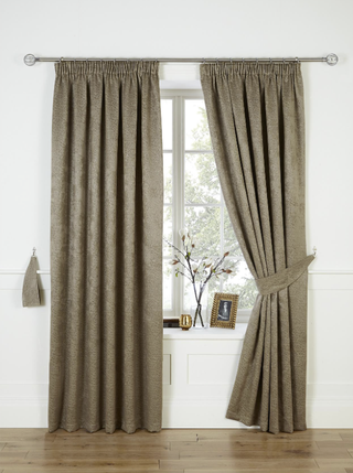 Cranley Thermal Blackout Curtains with one side pinned back showing a photo frame, decorative plant and candle on the windowsill