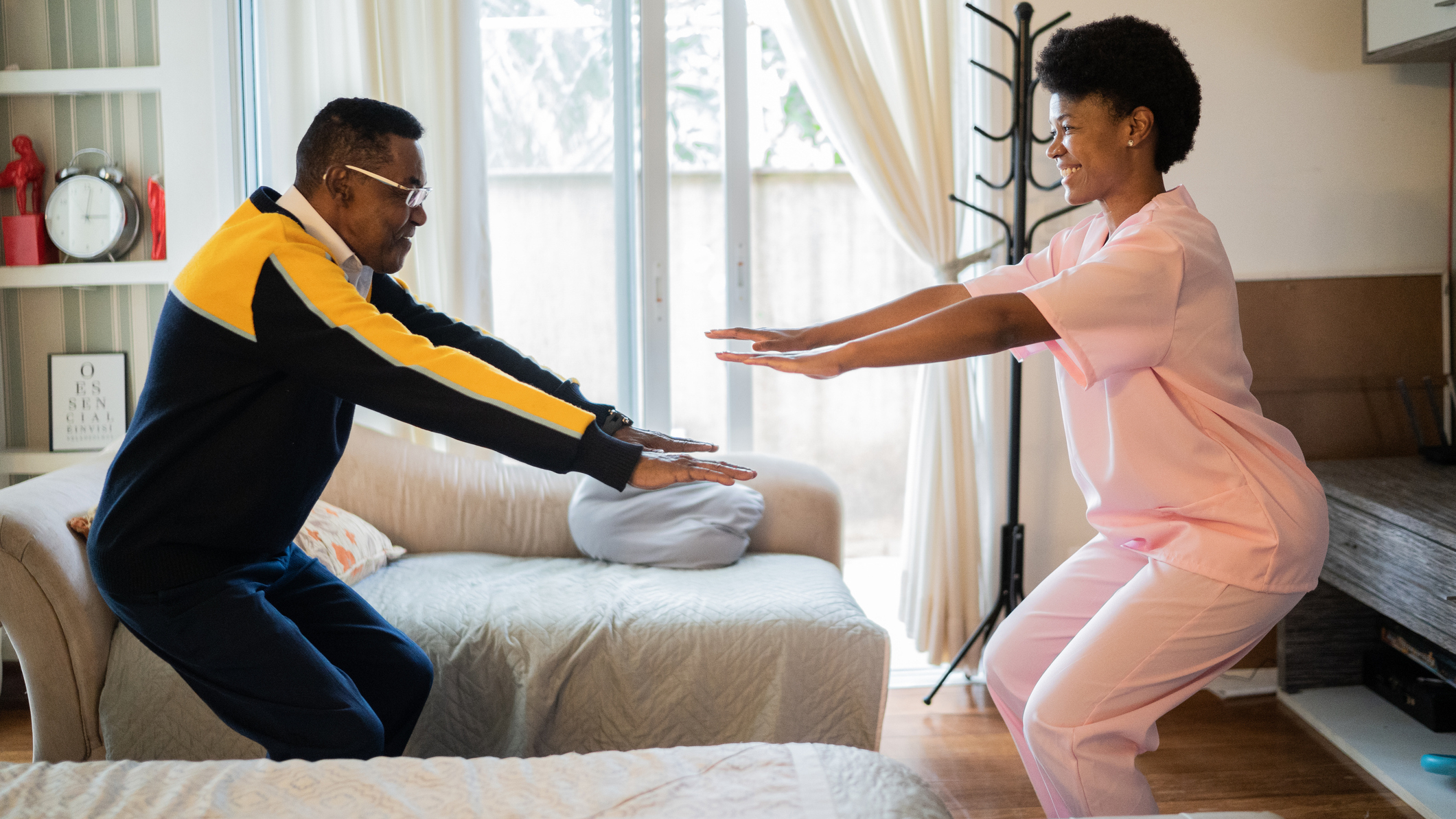Man and woman in domestic setting practising the squat exercise