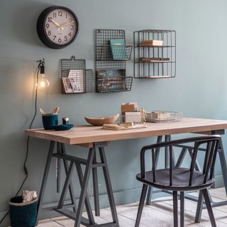 grey wall with storage basket clock wooden desk with black chair
