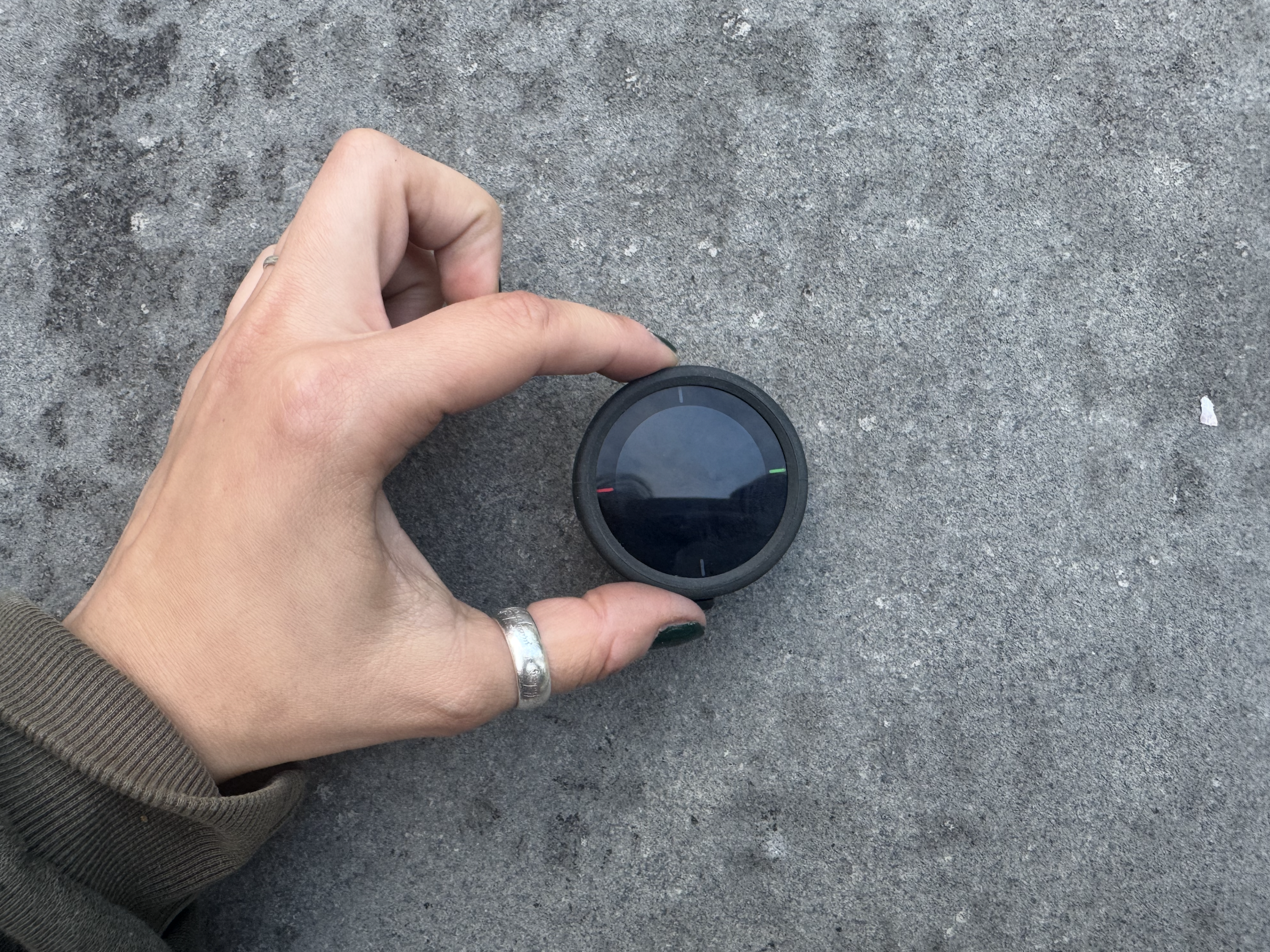 Held between the forefinger and thumb, the beeline velo sits on a grey background
