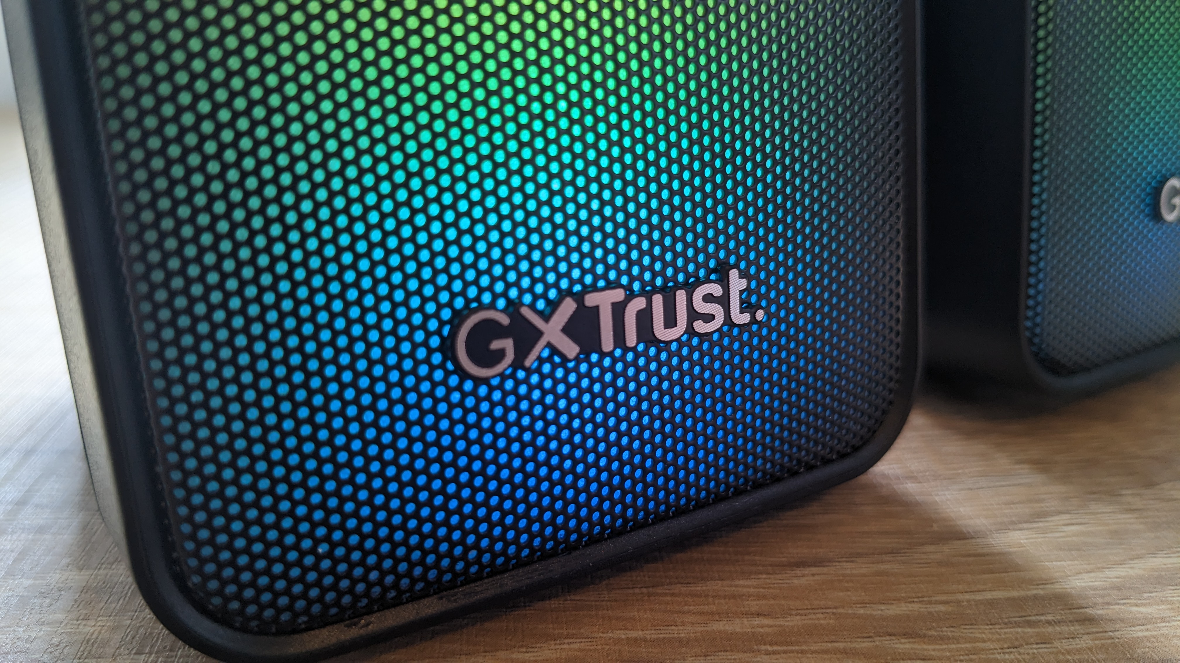 The Trust GXT 611 Wezz RGB speakers pictured on a wooden desk.