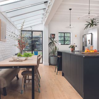 side return extension in an open plan kitchen diner with glazed roof and white brick walls