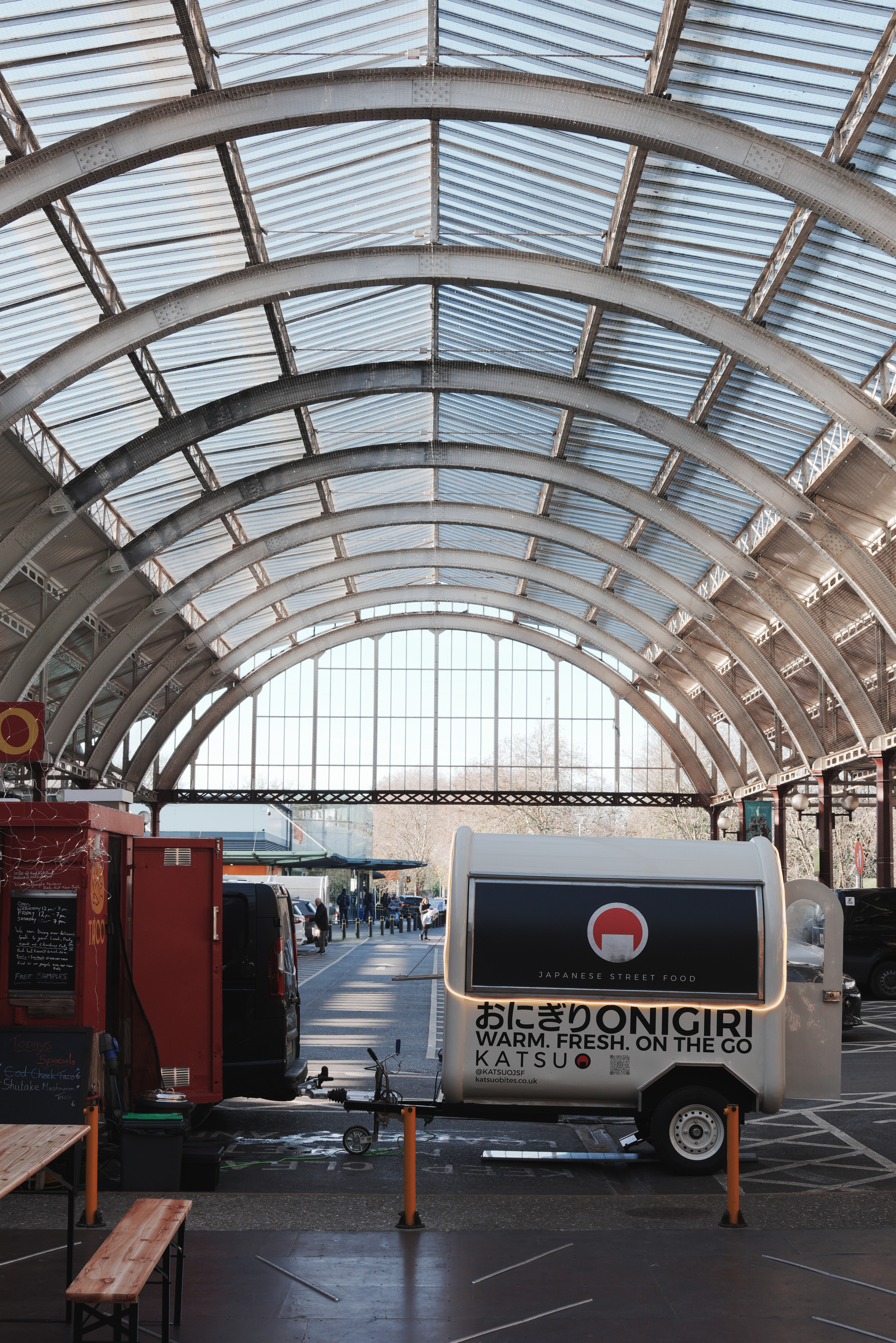 A photo of a Onigiri trailer under a vaulted metal roof