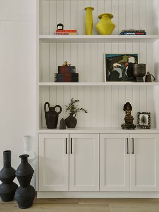 white paneled dresser with display shelves and artefacts on display