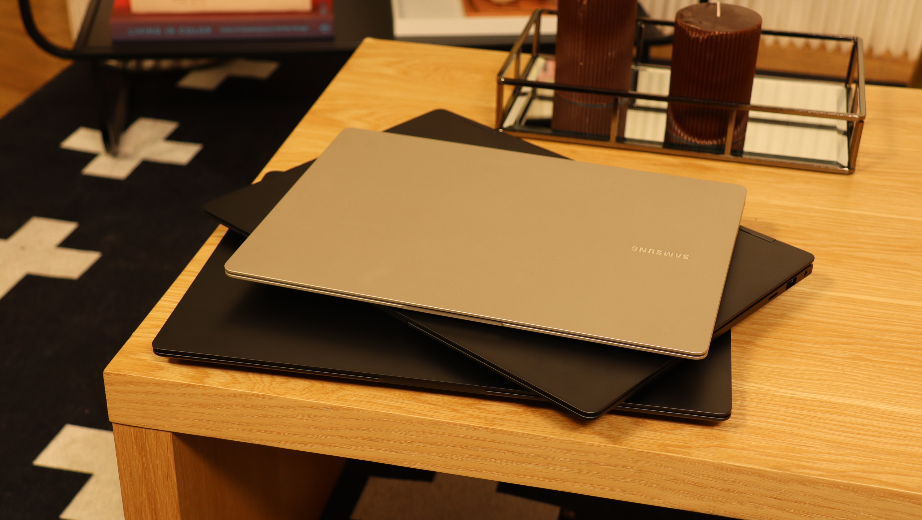 Three Samsung Galaxy Book3 piled up on a wooden table