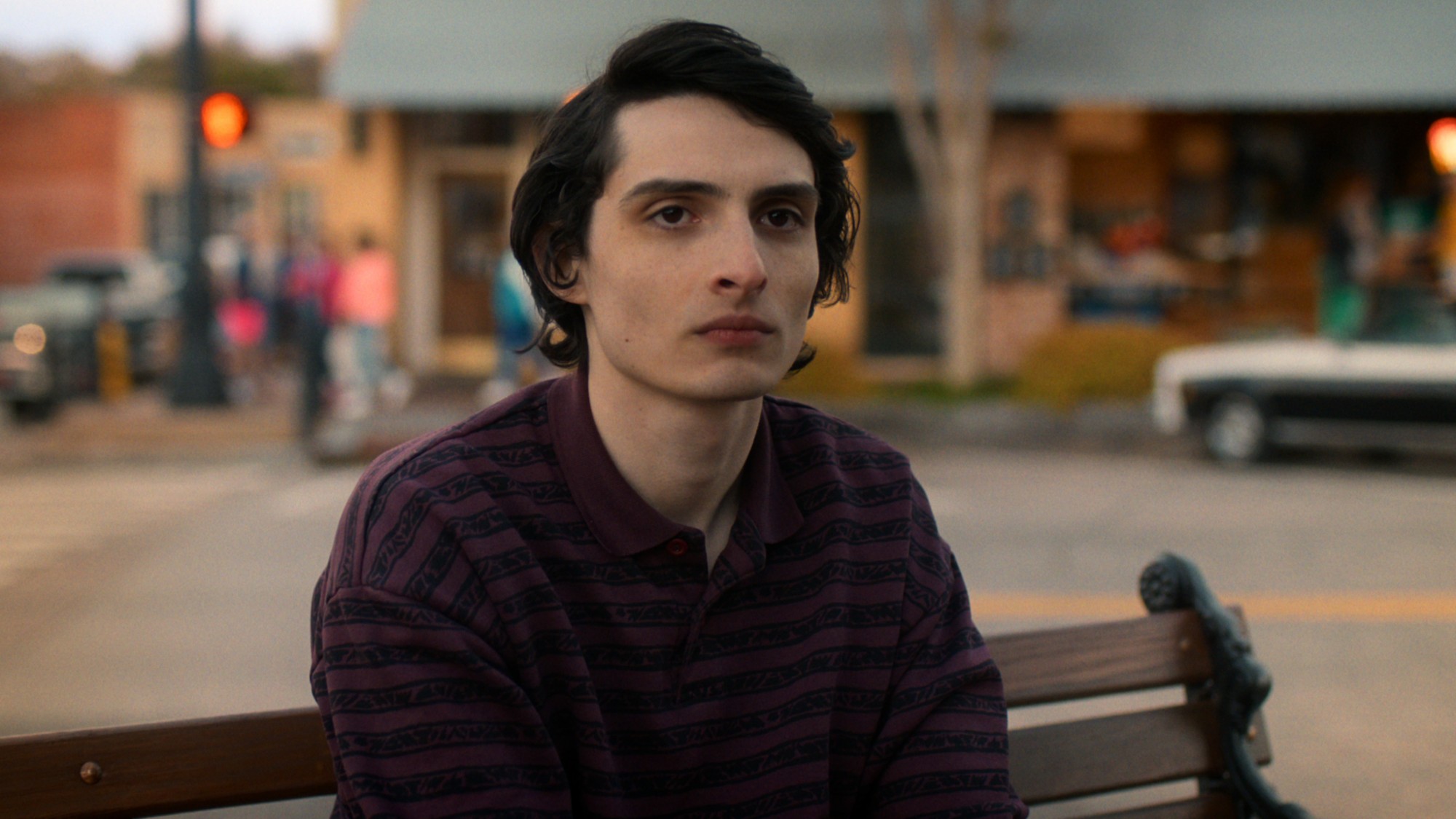 Mike sitting on a bench in Stranger Things.