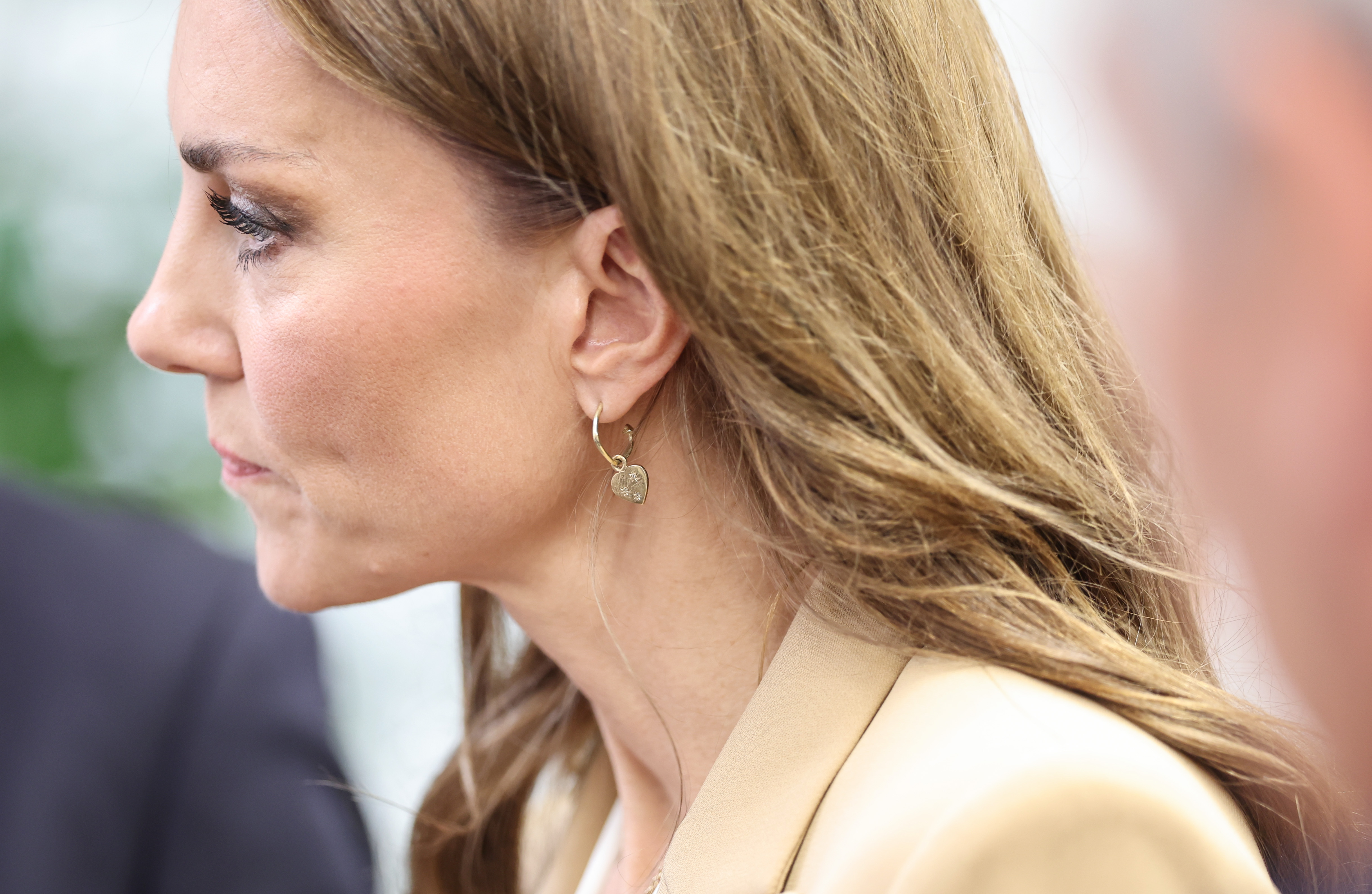 Princess Kate wearing a tan blazer and gold heart earrings