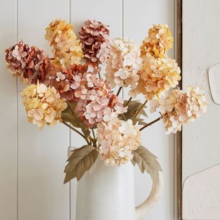 Faux Cone Hydrangea Bundle against a white wall.